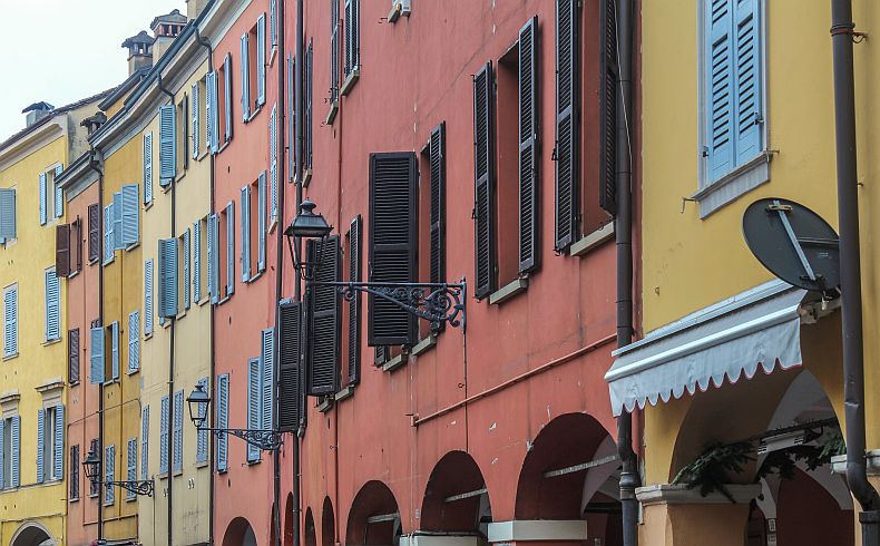 Colored residential buildings and window shutters in Modena